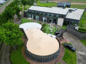 Luchtfoto van zandkleurige special shape stretchtent in hexagon-opstelling bij Hotel Den Berg in België