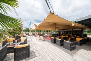 Breed horecaterras onder zandkleurige stretchtent