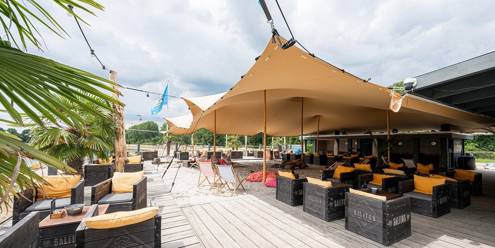 Breed horecaterras onder zandkleurige stretchtent